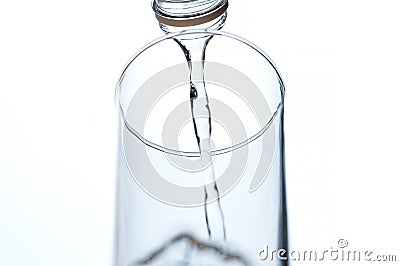 Water poured from a bottle into glass. Stock Photo