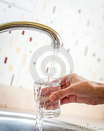 Water poured from tap to glass Stock Photo