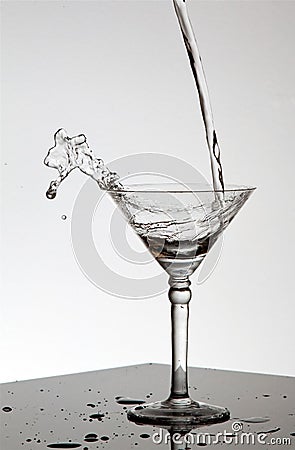 Water pouring in Martini glass Stock Photo