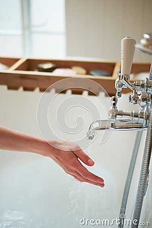 Water pours from the tap in the hands of the girl. the bathroom is bright. wedding concept Stock Photo