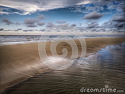Water reflection on the sea shore landscape on the sea shore with blue sky above. Stock Photo