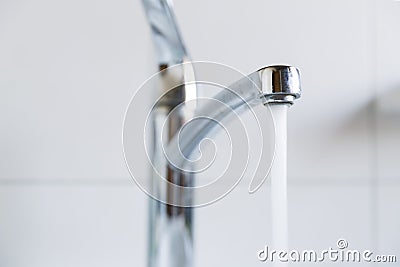 Water running from a tap into a bathroom sink Stock Photo