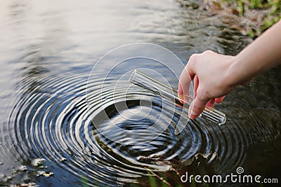 Water sample. Hand collects water to explore. Concept - water purity analysis, environment, ecology. Water testing for infections Stock Photo