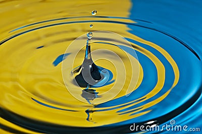 Water splash in yellow and blue Stock Photo