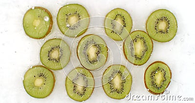 Water splashes in slow motion. Top view: several circles of kiwi is washed with water on a white background. chopped. Fruit stock video footage Water splashes in slow motion. Top view: several circles of kiwi is washed with water on a white background. chopped. Fruit stock video footage