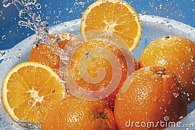 Water splashing on fresh oranges in strainer Stock Photo