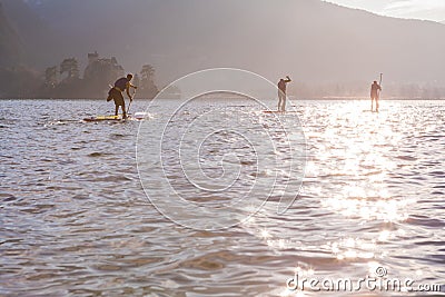 Water sport event. SUP racers are participating in sport event. Lake in France. Sunny winter day. excitement and rivalry Editorial Stock Photo