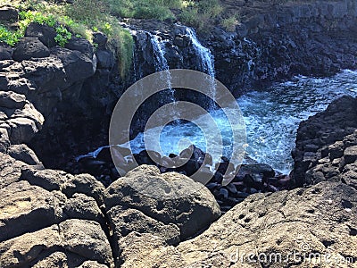 Water Stream Entering Pacific Ocean near Queen`s Bath in Princeville on Kauai Island, Hawaii. Stock Photo