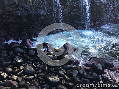 Water Stream Entering Pacific Ocean near Queen`s Bath in Princeville on Kauai Island, Hawaii. Stock Photo