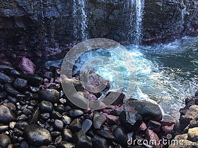 Water Stream Entering Pacific Ocean near Queen`s Bath in Princeville on Kauai Island, Hawaii. Stock Photo