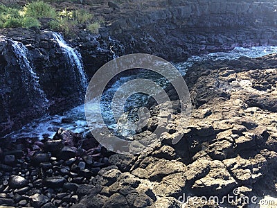 Water Stream Entering Pacific Ocean near Queen`s Bath in Princeville on Kauai Island, Hawaii. Stock Photo