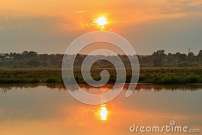 Water surface of river at sunset with reflection of orange sun. River landscape Stock Photo