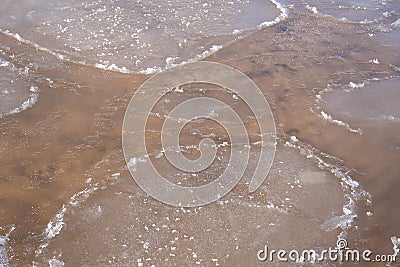 ater swirls and forms a texture through which you can see yellow sand Stock Photo