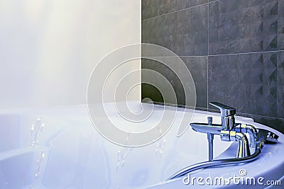 Water tap sink with faucet detail of jacuzzi with wall mount shower attachment Stock Photo