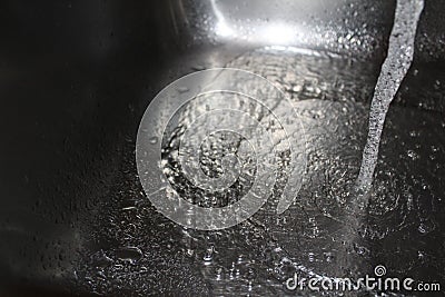 Water from tap splashing in sink Stock Photo