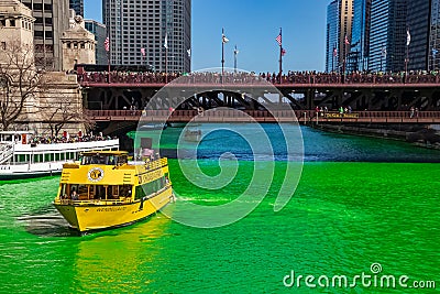 Water Taxi and tour boat on a dyed-green Chicago River as crowds gather on Michicagn Ave Editorial Stock Photo