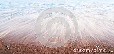 Water washed like mist over sand. Stock Photo