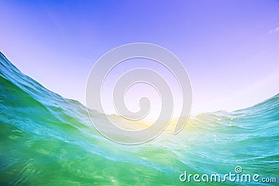 Water wave in the ocean. Underwater and blue sunny sky. Stock Photo