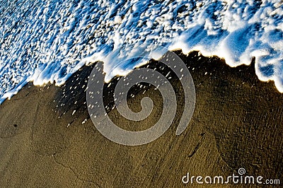 Water wave spume on the beach Stock Photo