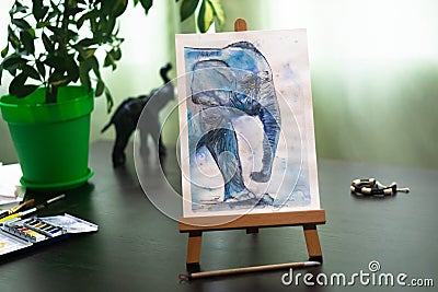 Watercolor drawing of an elephant standing on a small easel. Stock Photo