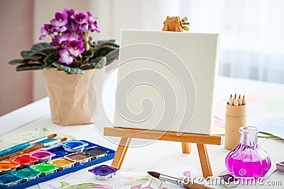 Watercolor paints, brushes , canvas on easel Stock Photo