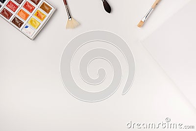 Watercolor paints, brushes, white canvas on white background Stock Photo