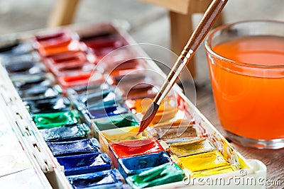 Watercolor paints and paintbrushes for painting closeup. Stock Photo