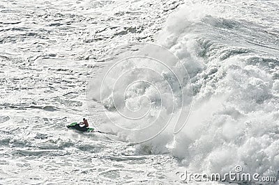 Watercraft escaping from a huge wave Stock Photo