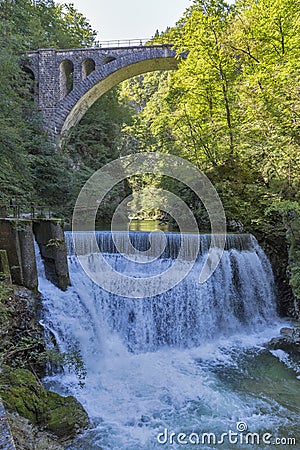 Waterfall beneath stone train bridge in the Vintgar gorge, Slovenia. Stock Photo