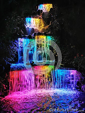 A waterfall cascade lit with bright colours at night Editorial Stock Photo