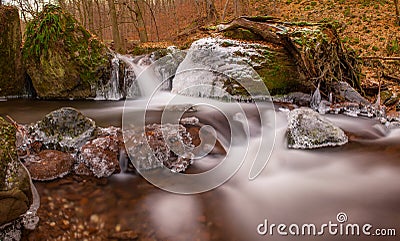 Waterfall cascades in cold winter temperatures. Frozen waterfall. Stock Photo