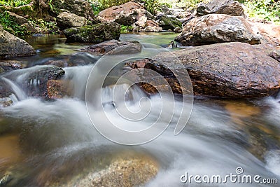 Waterfall cascades flowing over flat rocks in forest Stock Photo