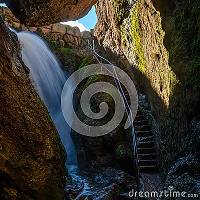 Waterfall in Cave Alongside Staircase Stock Photo