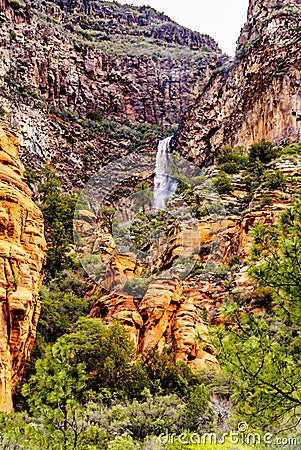 Waterfall coming down the colorful sandstone mountains in Oak Creek Canyon along Arizona SR89A between Sedona and Flagstaff Stock Photo