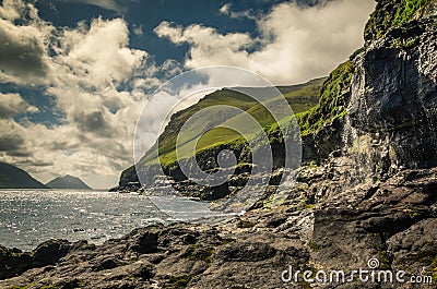 Waterfall falling down the cliff near Mikladalur village, view on the south towards island Bordoy and mountain Klakkur, Kalsoy Stock Photo