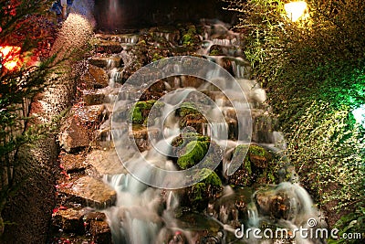 A waterfall on a minuature golf course at night Stock Photo