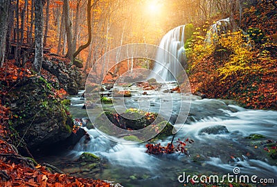 Waterfall at mountain river in autumn forest at sunset. Stock Photo