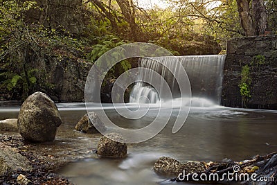 Waterfall on the mountain river in autumn. Stock Photo