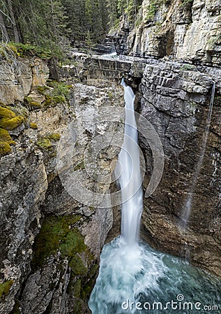 Waterfall over a Rock Cliff in the Canadian Rocky Mountains Stock Photo