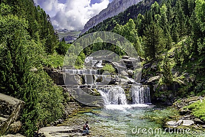 Waterfall on steps or terraces in green landscape between trees and mountains in Ordesa. Soaso stands. Spain Stock Photo