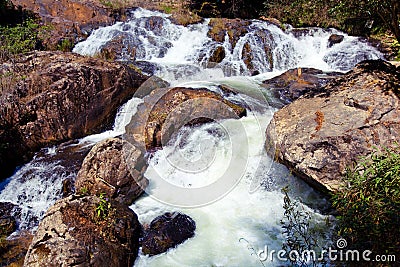 Waterfall with swift current between rocky stones Stock Photo