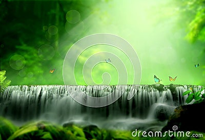 A waterfall in a tropical forest with sunlight shining Stock Photo