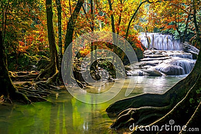 Waterfalls and fish swim in the emerald blue water in Erawan National Park. Erawan Waterfall is a beautiful natural rock waterfall Stock Photo