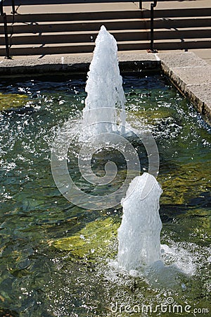 Two water fountains in a man made pond Stock Photo