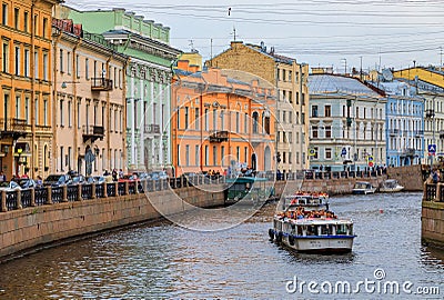 Waterfront buildings on the banks of river Neva and tourist boats on the water in Saint Petersburg Editorial Stock Photo