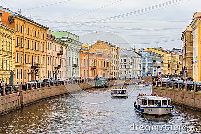 Waterfront buildings on the banks of river Neva and tourist boats on the water in Saint Petersburg Editorial Stock Photo