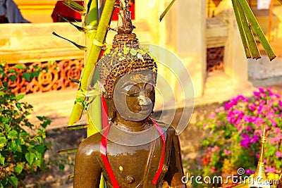 Watering Buddha statues with scented water and flower petals during Lao New Year - Pii Mai Lao - Song Kran - Water Festival in Apr Stock Photo