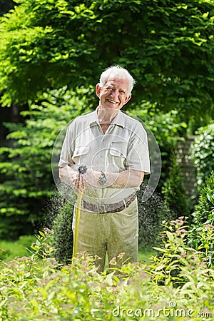 Watering grass with garden hose Stock Photo