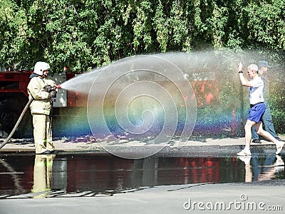 Watering a running athlete with water from a hose Editorial Stock Photo