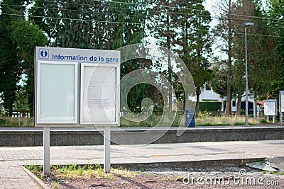 Waterloo,Belgium - July 25 2019: Information panel at the Waterloo train station on a sunny day with a blue garbage can in the Stock Photo